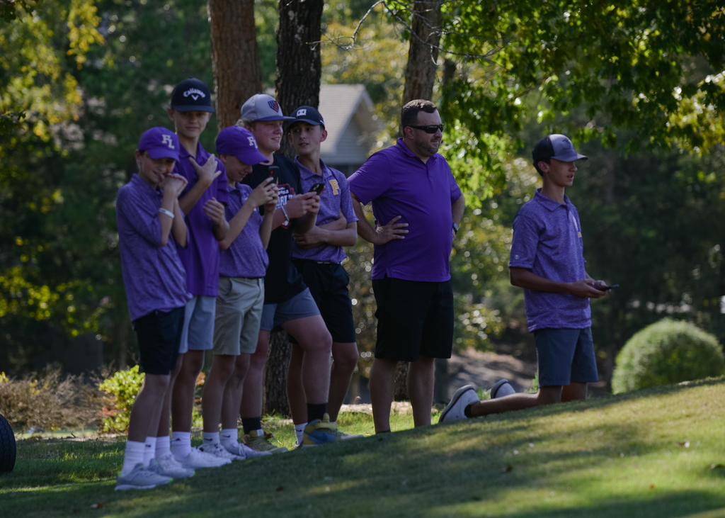 Coach Dettmerring and members of the golf team watch the action at the Dist. Tournament